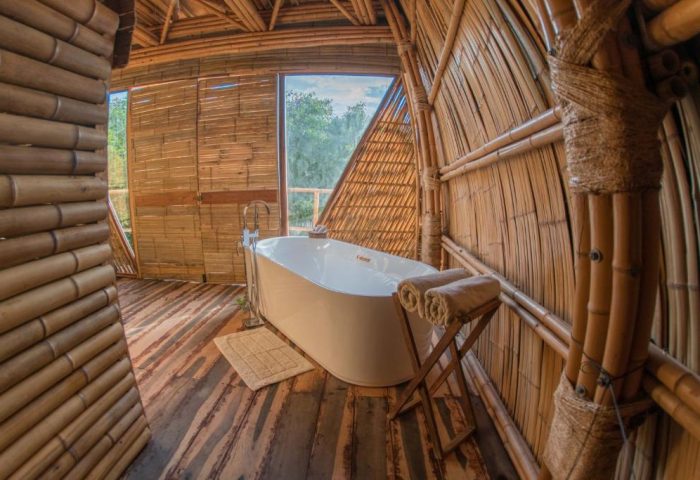 Bathroom in Mamasan Treehouses & Cabins, a gay-friendly hotel. Bamboo walls, wooden floor, and a modern bathtub. Great for gay men travel.