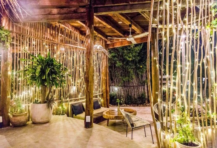 Outdoor lounge at gay-friendly Mamasan Treehouses & Cabins. Cozy seating, string lights, and natural wood design create a relaxing atmosphere.