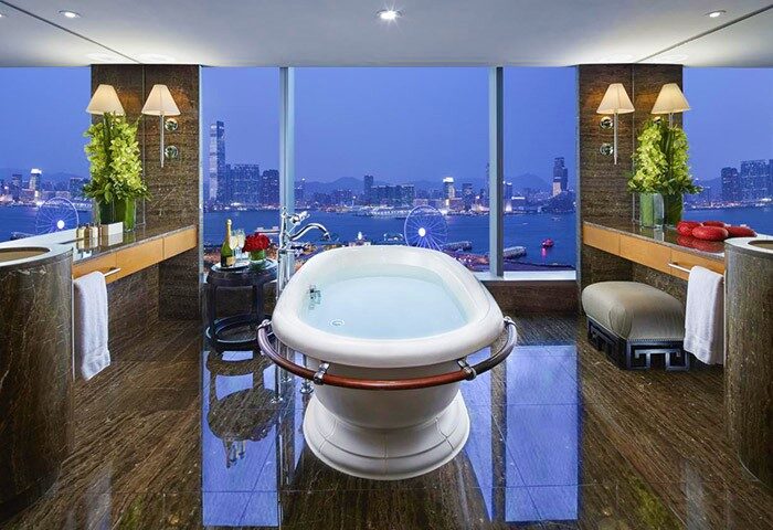 Luxurious bathroom at Mandarin Oriental, Hong Kong, a gay-friendly hotel. Bathtub with a stunning city view. Perfect for gay travel in Hong Kong.
