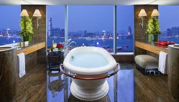 Luxurious bathroom at Mandarin Oriental, Hong Kong, a gay-friendly hotel. Bathtub with a stunning city view. Perfect for gay travel in Hong Kong.