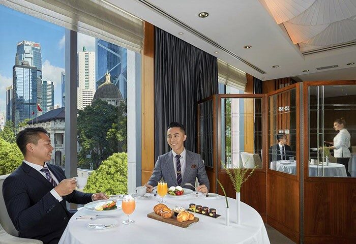 Gay-friendly Mandarin Oriental Hong Kong: Two men enjoy breakfast with city views. Upscale dining at this top Hong Kong hotel.
