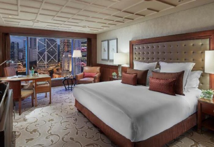 Mandarin Oriental Hong Kong gay-friendly hotel room view. Luxury bedroom with Hong Kong skyline. Gay travel hotel.
