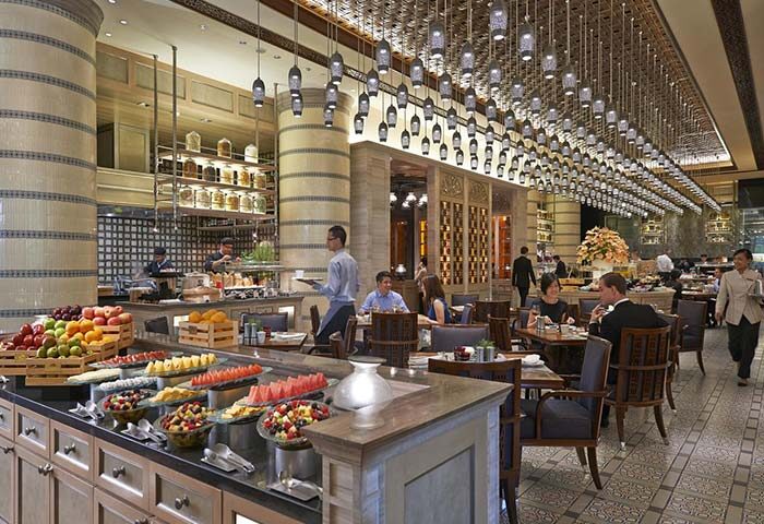 Gay-friendly Mandarin Oriental Kuala Lumpur restaurant. Buffet with fruit, patrons dining. Luxury hotel. Fine dining experience.
