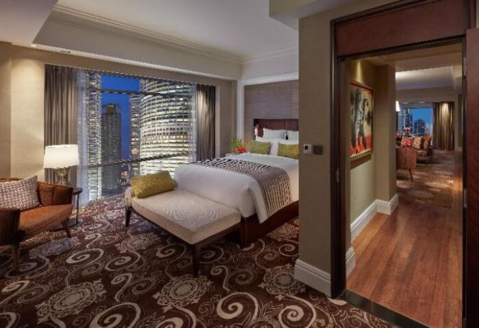 Gay-Friendly Hotel Mandarin Oriental Kuala Lumpur suite. City views, bedroom, and living room. Luxury gay travel in Malaysia.