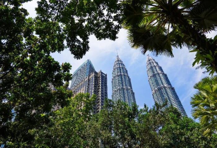 Kuala Lumpur's Petronas Towers and Mandarin Oriental Hotel seen through trees. Gay-friendly hotel for gay men travelers in Malaysia.