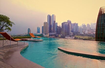 Manhattan Hotel's rooftop pool with city view. Gay-friendly hotel offers luxury with skyline views. Loungers by the infinity pool.