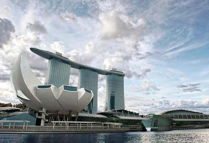 Marina Bay Sands, a gay-friendly hotel, in Singapore. The iconic building with its unique architecture stands tall against a cloudy sky.