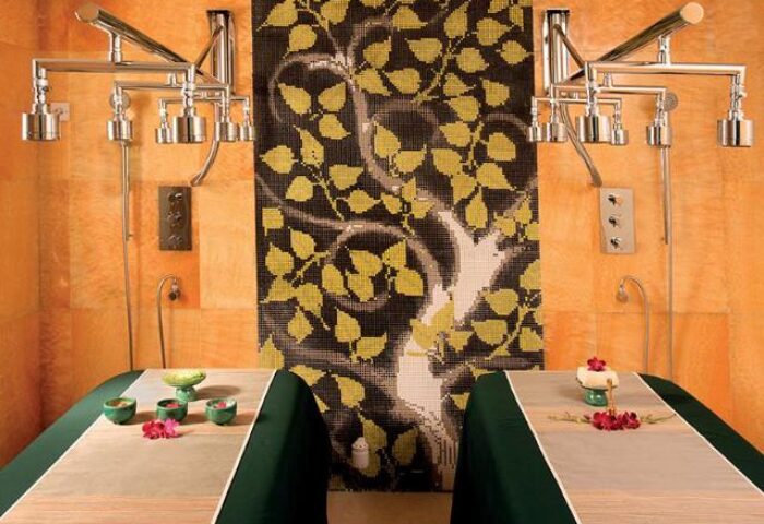 Gay-friendly Marina Bay Sands: Spa room with massage beds, mosaic tree art, and multi-jet shower fixtures. Luxury travel for gay men.