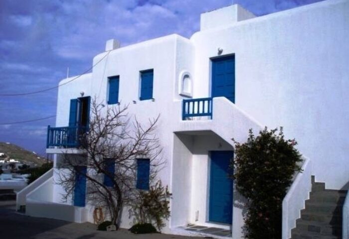 Marina Blue Ornos gay-friendly hotel. White building with blue doors and window frames. Typical Greek architecture in Mykonos.