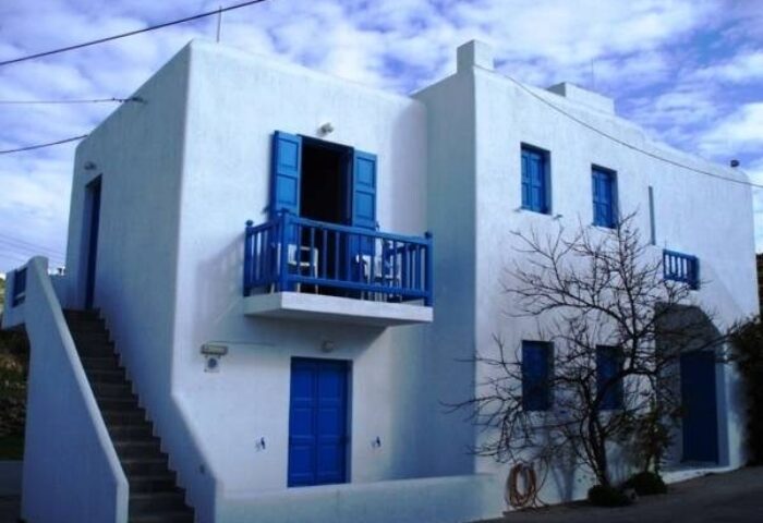 Marina Blue Ornos gay-friendly hotel. White building with blue doors and shutters. Balcony view. Gay travel advice for Ornos, Greece.