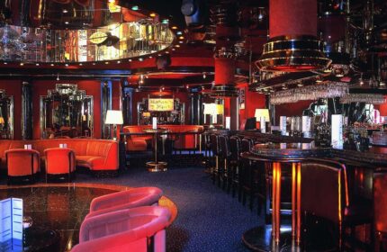 Gay-friendly Maritim Hotel Koeln bar. Red interior, mirrored ceiling, plush seating. A stylish spot in Cologne for LGBT travelers to enjoy.