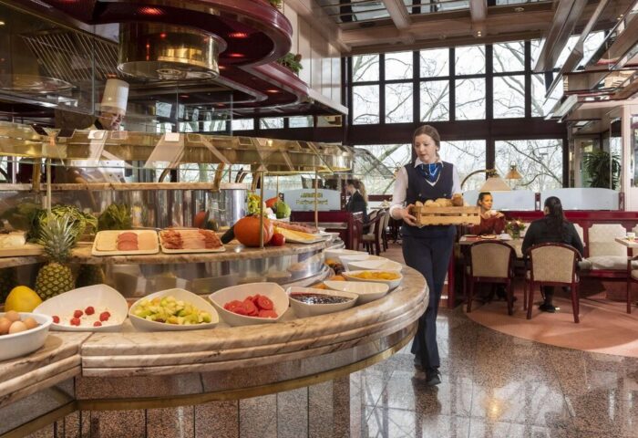 Maritim Hotel Koeln breakfast buffet. Staff member carries bread. Gay-friendly hotel offers diverse food options. Hotel in Cologne, Germany.