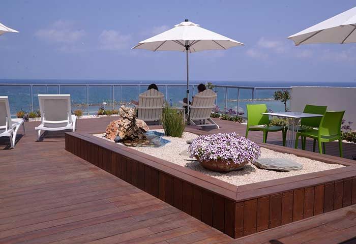 Maxim Design Hotel 3 Star Superior rooftop. Gay-friendly hotel with sea view, lounge chairs, tables, and a decorative garden. Perfect for gay travel.