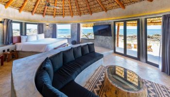 Gay-friendly Maya Tulum By G Hotels suite with thatched roof, ocean view, & stylish decor. Ideal gay travel destination for relaxation.