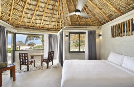 Maya Tulum By G Hotels room. Beach view, thatched roof, white linens. Gay-friendly hotel. Tulum travel for gay men.