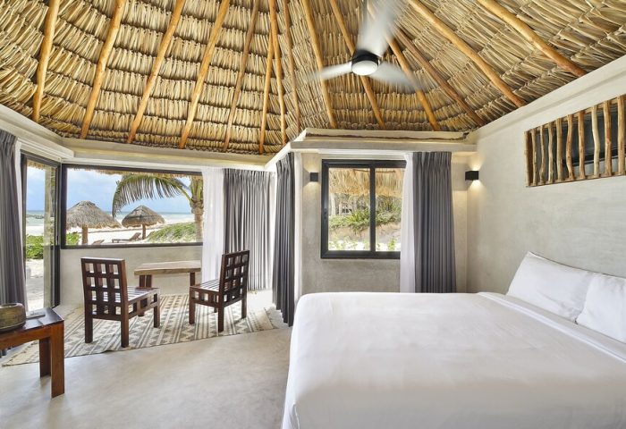 Maya Tulum By G Hotels room. Beach view, thatched roof, white linens. Gay-friendly hotel. Tulum travel for gay men.