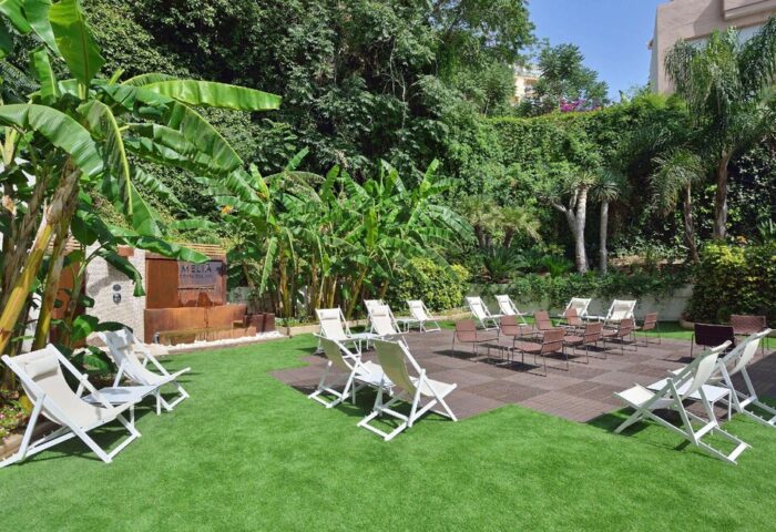Melia Costa del Sol's garden with chairs. A gay-friendly hotel with lush greenery, a relaxing area, and outdoor seating. Perfect for gay travelers.
