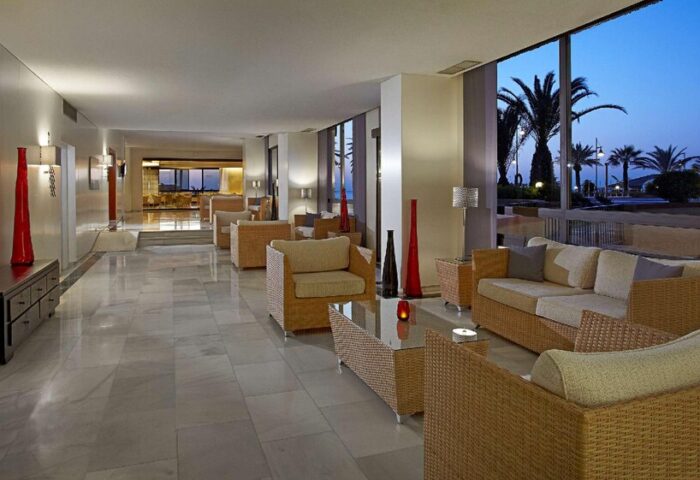 Melia Costa del Sol gay-friendly hotel lobby with wicker furniture and palm tree views. A stylish, welcoming space for gay travelers.