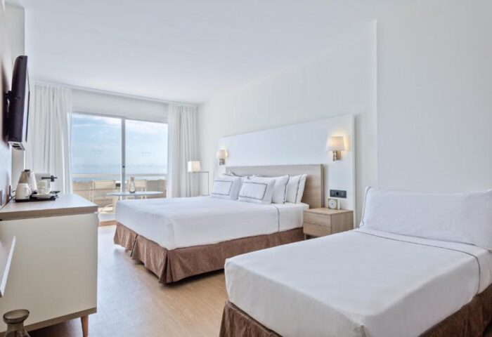Melia Sitges gay-friendly hotel room. Bright, modern interior with two beds, TV, and balcony overlooking the sea. Ideal for gay travel.