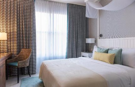Melody Hotel, an Atlas Boutique Hotel room. Gay-friendly hotel room with bed, pillows, desk and chair. Modern decor, bright, and welcoming.