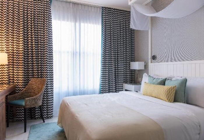 Melody Hotel, an Atlas Boutique Hotel room. Gay-friendly hotel room with bed, pillows, desk and chair. Modern decor, bright, and welcoming.