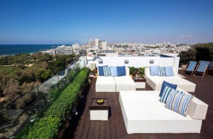 Melody Hotel, an Atlas Boutique Hotel rooftop terrace. Gay-friendly hotel with ocean view. Lounge chairs and city skyline in Tel Aviv.