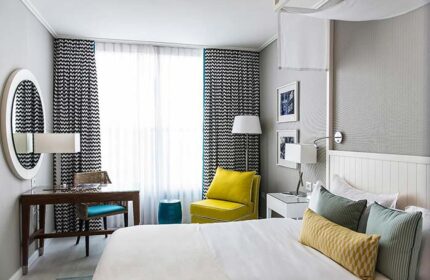 Melody Hotel, an Atlas Boutique Hotel room. Gay-friendly hotel room with a desk, bed, chair, and patterned curtains. Modern design.