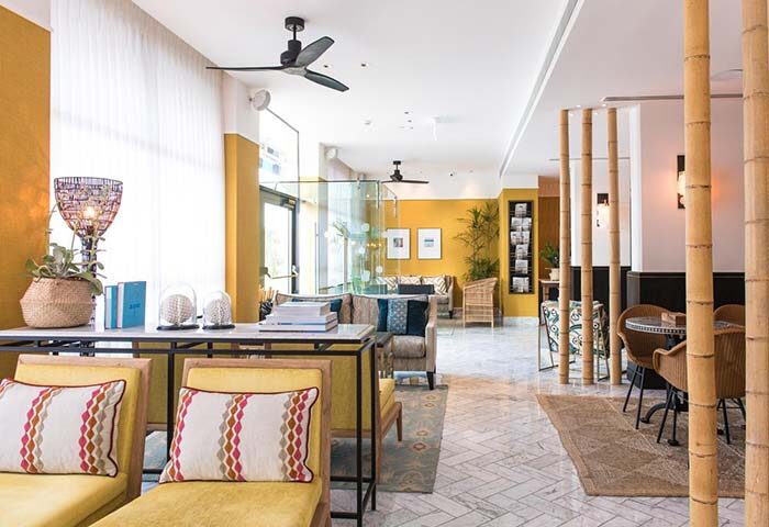 Melody Hotel, an Atlas Boutique Hotel: Stylish, gay-friendly hotel lobby with yellow walls, bamboo accents, and comfortable seating.
