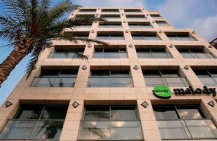 Melody Hotel, an Atlas Boutique Hotel. Gay-friendly hotel exterior view with palm tree. Modern building with balconies.