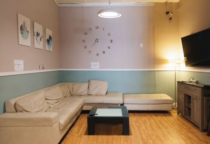 Melrose Hostel Adults Only lounge area. Gay-friendly hotel with comfortable seating, TV, and modern decor. Perfect for relaxing and socializing.