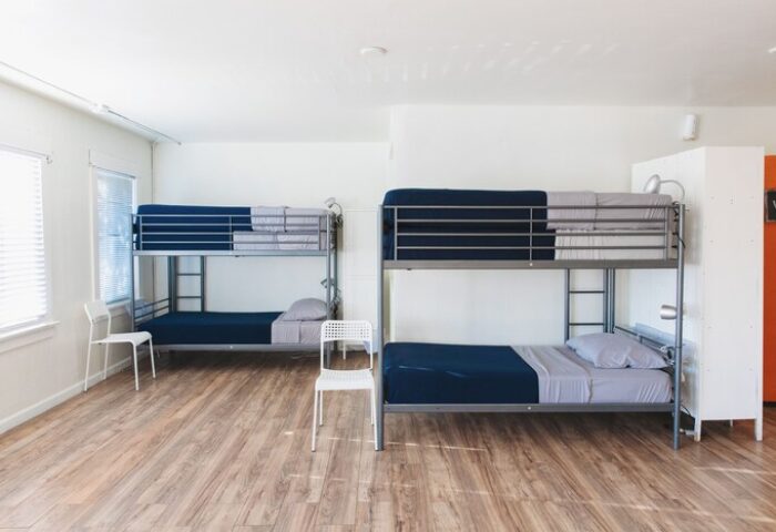 Melrose Hostel Adults Only room. Two bunk beds with blue sheets. Gay-friendly hotel for men. Budget travel accommodation.