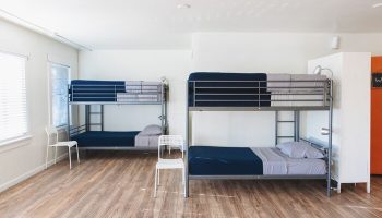 Melrose Hostel Adults Only room. Two bunk beds with blue sheets. Gay-friendly hotel for men. Budget travel accommodation.