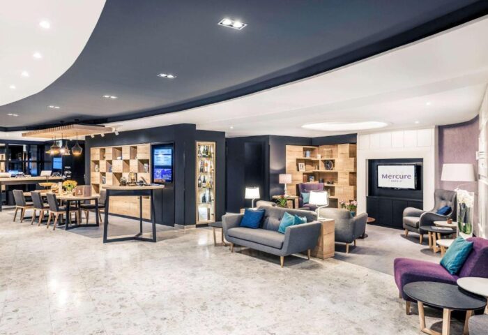 Mercure Budapest City Center Hotel lobby. Gay-friendly hotel with modern design, seating areas, tables, and a relaxed atmosphere. Perfect for gay travel.
