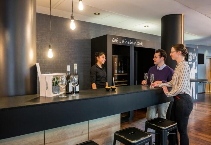 Bar at Gay-Friendly Mercure Hotel Berlin Zentrum. Guests enjoy drinks at the stylish bar with friendly service. Wine selection available.