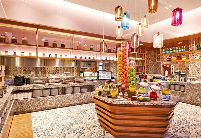 Mercure Kuala Lumpur Shaw Parade gay-friendly hotel breakfast buffet. Colorful lanterns hang above food stations with fruit and hot dishes.