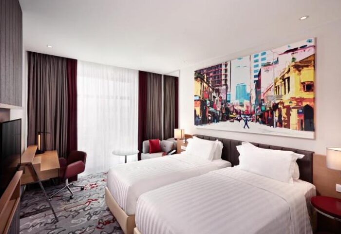 Gay-friendly Mercure Kuala Lumpur Shaw Parade hotel room. Two beds, desk, city art. Comfortable stay in Kuala Lumpur, Malaysia.