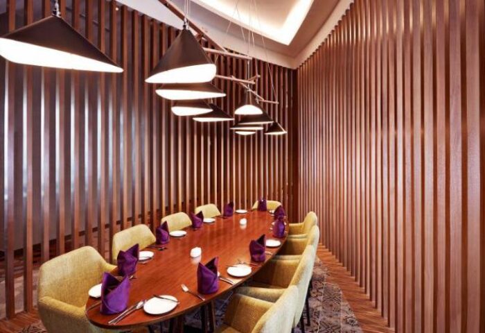 Dining area at the gay-friendly Mercure Kuala Lumpur Shaw Parade Hotel. Long table set for dinner with stylish lighting and decor.
