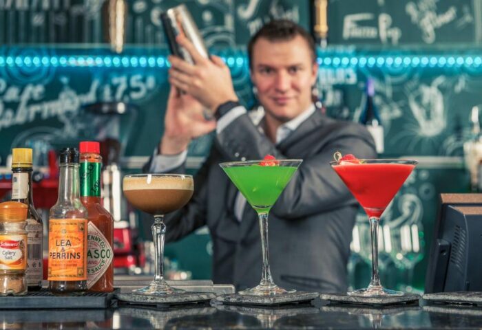 Mercure London Bridge gay-friendly hotel: Bartender shaking cocktails. Colorful drinks at the bar, perfect for LGBTQ+ travelers.