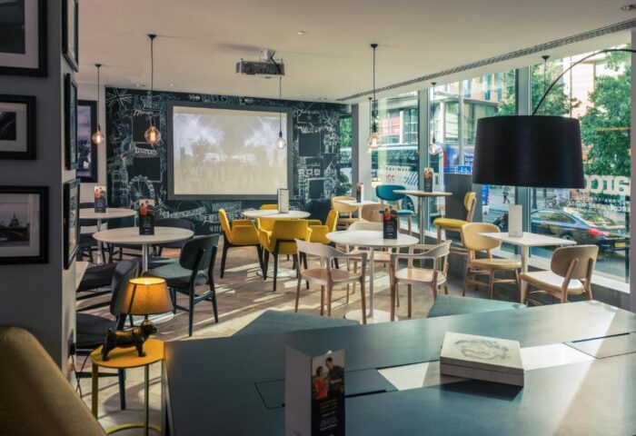 Mercure London Bridge gay-friendly hotel interior. Modern decor, projector screen, tables, and chairs create a welcoming space for gay travelers.