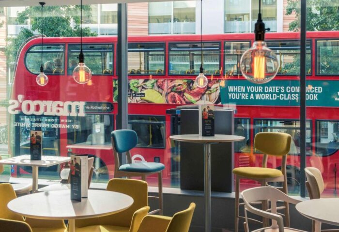 Mercure London Bridge gay-friendly hotel interior. Tables and chairs with a London bus passing by. Modern design, ideal for gay travelers.