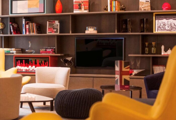Interior of Gay-Friendly Mercure London Bridge Hotel. Shelves with books, art, and London-themed decor. Cozy seating area. Modern design.