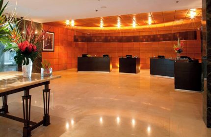 Mexico City Marriott Reforma Hotel lobby. Gay-friendly hotel reception area with desks, floral arrangements, and warm lighting. Mexico travel.