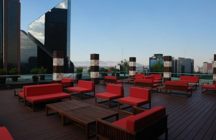 Rooftop lounge at Mexico City Marriott Reforma Hotel. Gay-friendly hotel with red seating and city views. Ideal for gay travel in Mexico City.