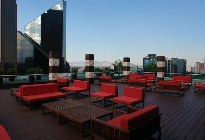 Rooftop lounge at Mexico City Marriott Reforma Hotel. Gay-friendly hotel with red seating and city views. Ideal for gay travel in Mexico City.