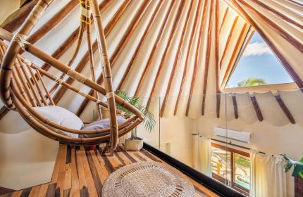 Mezzanine at Colibri Boutique Hotel (Adults Only). Gay-friendly hotel room with hanging chair, wooden floor, and triangular window view.