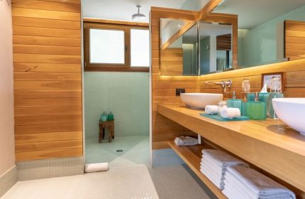 Bathroom at Mi Amor a Colibri Boutique Hotel Adults Only. Gay-friendly hotel with wood counters, dual sinks, & walk-in shower. Modern design.