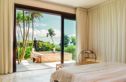 Mi Amor a Colibri Boutique Hotel adults-only room. Gay-friendly hotel with a view of the jacuzzi, statue, and palm trees.