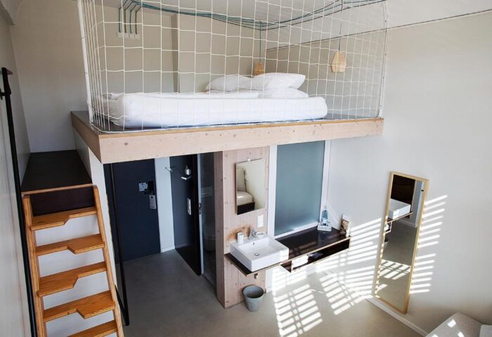 Michelberger Hotel's unique room design. Loft bed with net, ladder access. Modern bathroom. A gay-friendly hotel with style in Berlin.