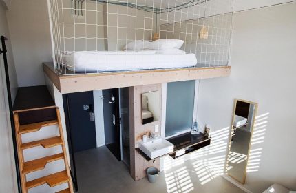 Michelberger Hotel's unique room design. Loft bed with net, ladder access. Modern bathroom. A gay-friendly hotel with style in Berlin.