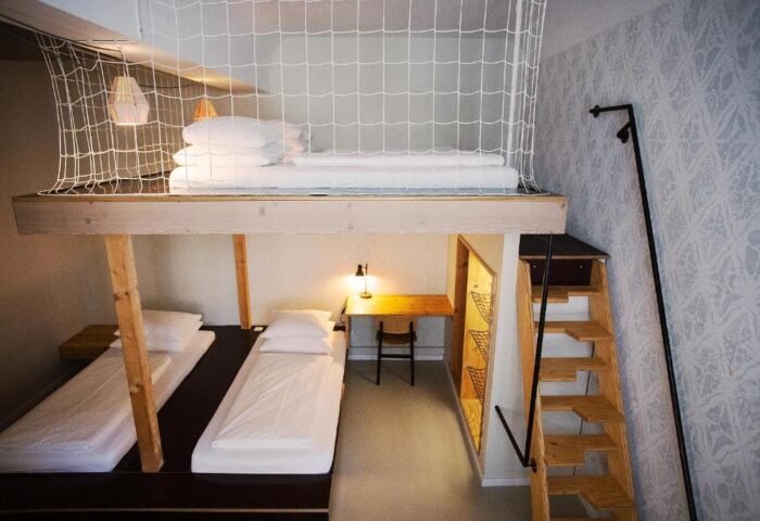 Michelberger Hotel room with bunk beds. Gay-friendly hotel with unique design. Loft bed with safety net, workspace, & stairs. Quirky, stylish decor.